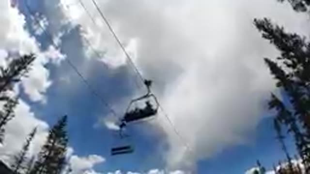 People Riding A Ski Lift In The Sky On A Cloudy Day