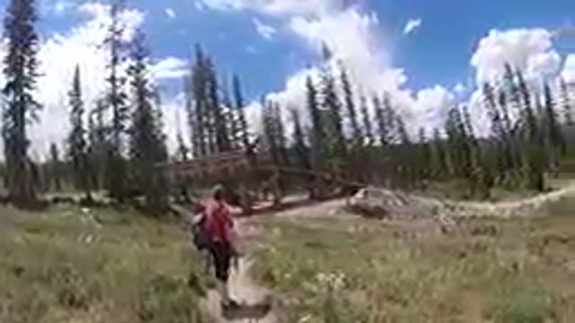 Woman Walking On A Trail In The Mountains With A Backpack