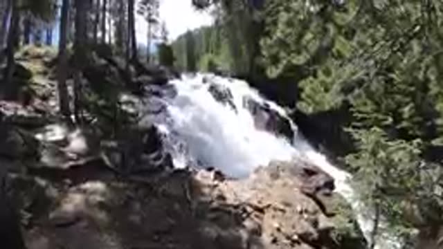 Waterfall That Is Flowing Down A Hill In The Woods