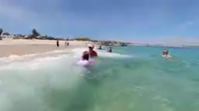 CABO BAJA CALIFORNIA SUR MEXICO-2019: Family Swimming In Shallow Turquoise Ocean Water