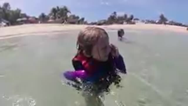 CABO BAJA CALIFORNIA SUR MEXICO-2019: Toddler Wearing Wetsuit Splashing In Shallow Ocean