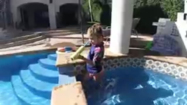 Young Boy Standing In A Pool With A Toy