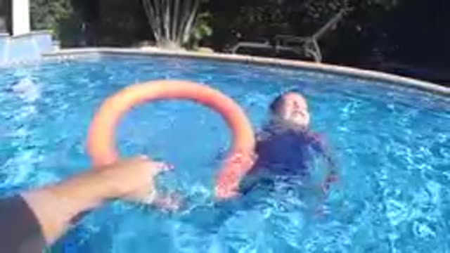 CABO BAJA CALIFORNIA SUR MEXICO-2019: Child Swimming Toward Orange Ring In Pool