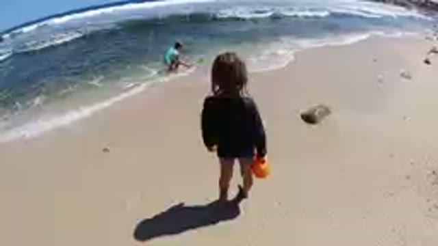 Los Cabos, Mexico-2019: Little Girl Watches her Mom Collecting Beach Stones
