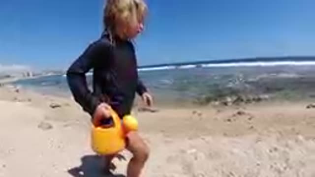 CABO BAJA CALIFORNIA SUR MEXICO-2019: Child Playing With Yellow Bucket On Beach