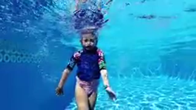 Woman In A Wetsuit Swimming Under Water