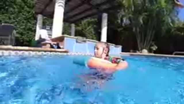 Little Girl That Is Floating In The Pool