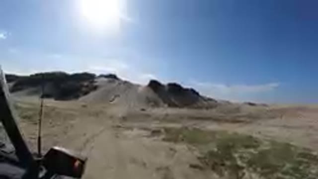 Vehicle Driving On A Dirt Road Near A Hill