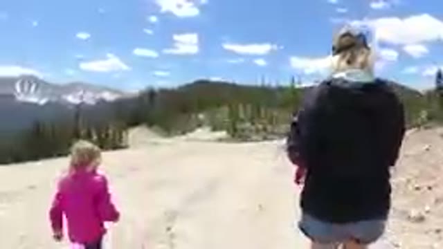 Woman And A Child Walking Down A Dirt Road