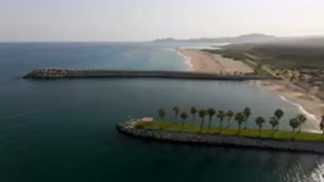 PUERTO LOS CABOS BCS MEXICO-2023: Beach With A Long Pier And Palm Trees