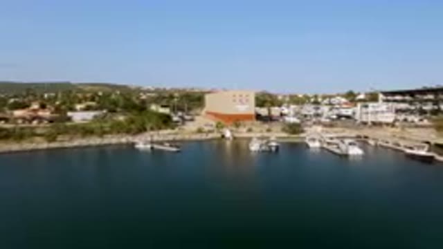 PUERTO LOS CABOS BCS MEXICO-2023: Boats Are Docked In A Harbor Near A Large Structure