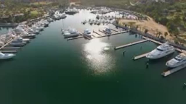 PUERTO LOS CABOS BCS MEXICO-2023: Marina With Boats Docked And A City In The Background
