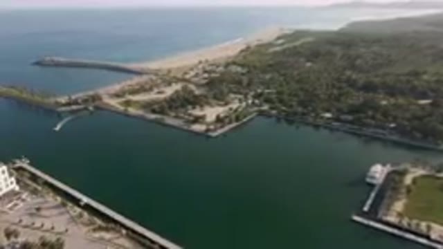 PUERTO LOS CABOS BCS MEXICO-2023: Aerial Large Body Of Water With A Beach And A Pier
