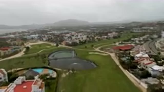 SAN JOSE DEL CABO BCS MEXICO-2023: Aerial Golf Course With A Pond And A City In