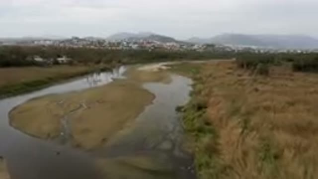 SAN JOSE DEL CABO BCS MEXICO-2023: River Running Through A Field With A City In