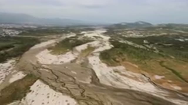 SAN JOSE DEL CABO BCS MEXICO-2023: River Running Through A Valley With A Town In Distance