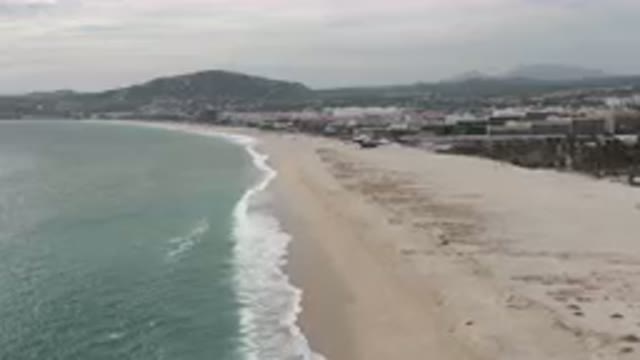 SAN JOSE DEL CABO BCS MEXICO-2023: Beach With A Few Houses And A Mountain In The Background
