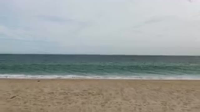SAN JOSE DEL CABO BCS MEXICO-2023: Man Sitting On The Beach With A Cell Phone