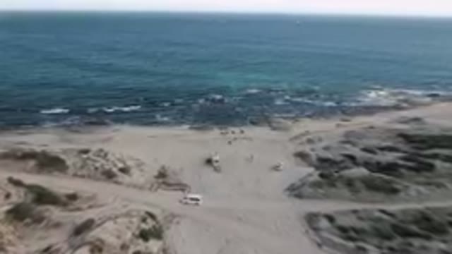 SHIPWRECKS BEACH LOS CABOS BCS MEXICO-2023: Aerial View of Shipwreck and Parked Vehicles on Sandy Shore