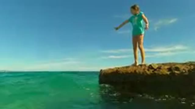 PALMILLA BCS MEXICO-2023: Young Girl Waves From A Rock In The Ocean