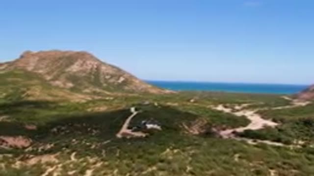 CABO PULMO BCS MEXICO-2023: Large Hill With A House On It And A Beach In The
