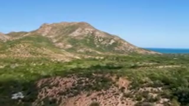 CABO PULMO BCS MEXICO-2023: Mountains With A Blue Sky And A Body Of Water In The