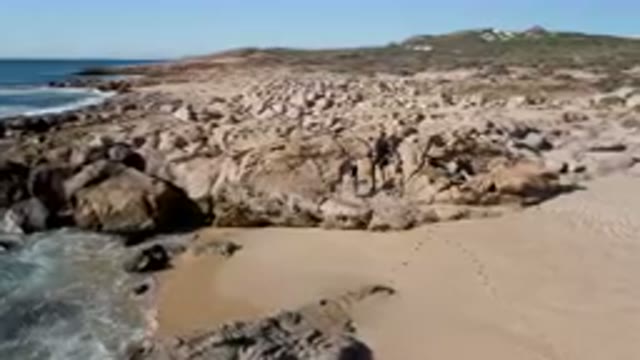 LAGUNA BEACH LOS CABOS BCS MEXICO-2023: People atop a rocky shoreline
