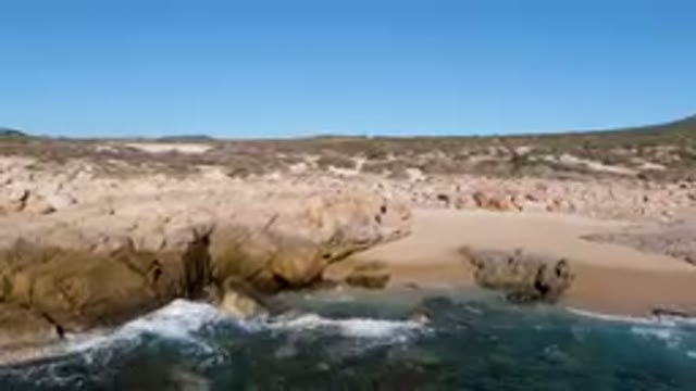 LAGUNA BEACH LOS CABOS BCS MEXICO-2023: Man Standing On A Rock Cliff By The Ocean