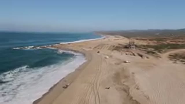 MIGRINO BCS MEXICO-2023: Truck Driving Along The Beach With Waves And Sand
