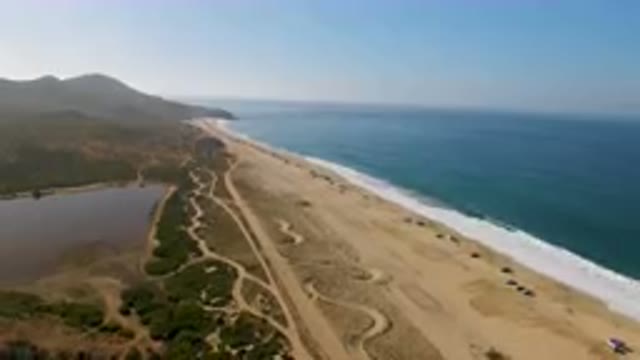 MIGRINO BCS MEXICO-2023: Aerial Beach With A Body Of Water And A Mountain