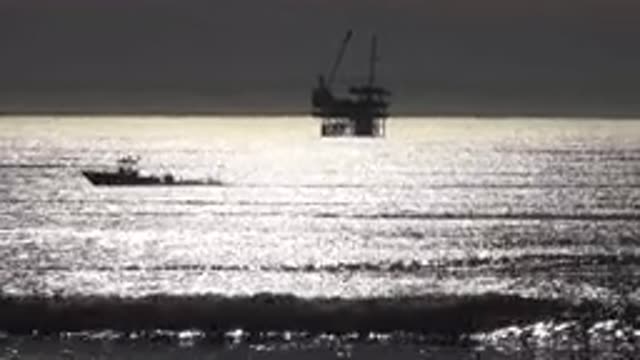 MALIBU CALIFORNIA-2020: Boat Speeding Over Ocean in Front of Oil Rig Platform