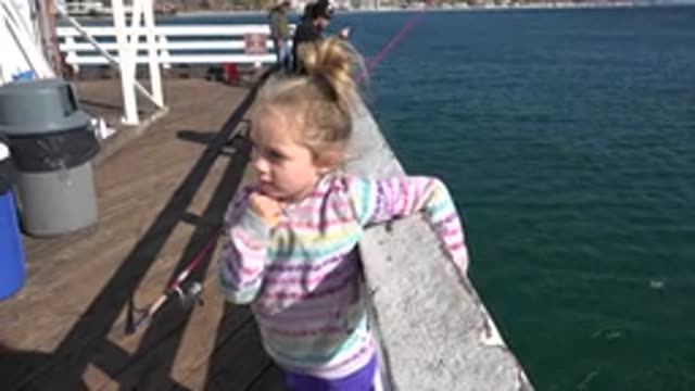 MALIBU CALIFORNIA-2020: Young Girl In Sweatshirt Hanging On Railing Next To The Ocean