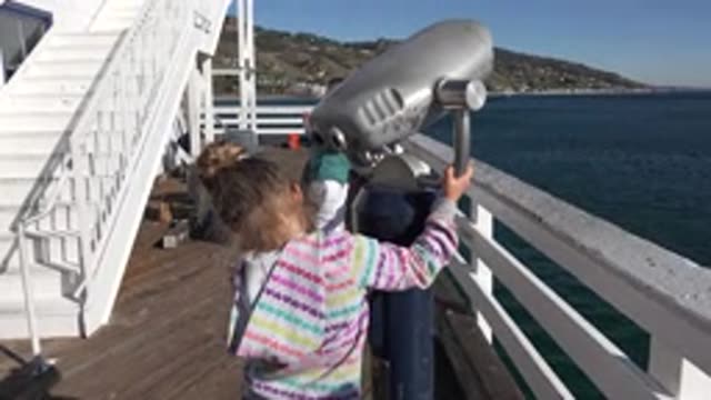 MALIBU CALIFORNIA-2020: Girl Wearing White Striped Shirt Holds Grey Binocular