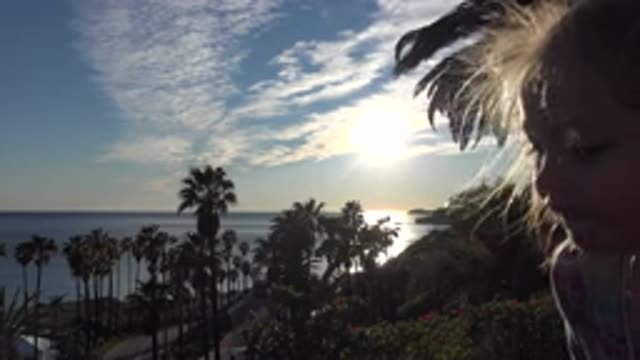 MALIBU CALIFORNIA-2020: Little Girls Face Bobs in Front of Palm Trees