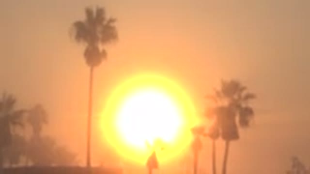 HUNTINGTON BEACH CALIFORNIA-2020: A Giant Sun Lights Up A Landscape With Some