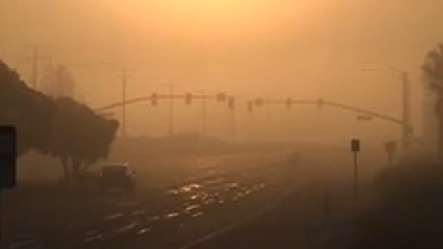 HUNTINGTON BEACH CALIFORNIA-2020: A Car Driving on a Road Under an Orange Sky