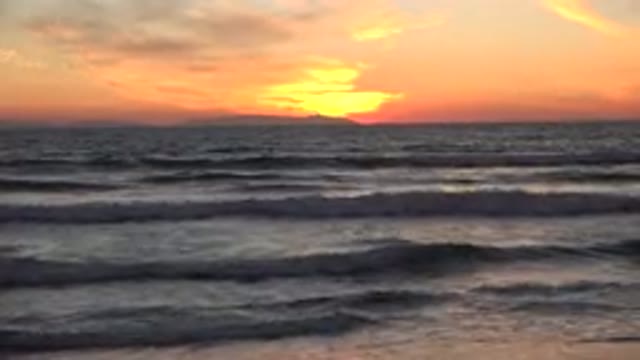 HUNTINGTON BEACH CALIFORNIA-2020: Waves On The Shore Of The Ocean With Red Sky