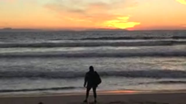 HUNTINGTON BEACH CALIFORNIA-2020: A Person Relaxing by the Ocean at Sunset