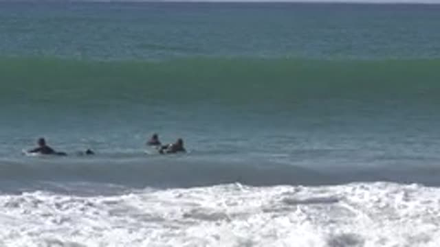 HUNTINGTON BEACH CALIFORNIA-2020: Three People On Surfboards Swimming Out