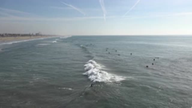 HUNTINGTON BEACH CALIFORNIA-2020: Waves Rush Over Beachgoers Bathing In The Sea