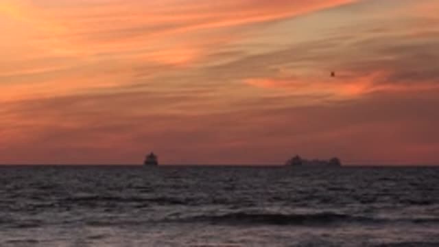 HUNTINGTON BEACH CALIFORNIA-2020: View Of Gold Sunset And Distant Grey Objects