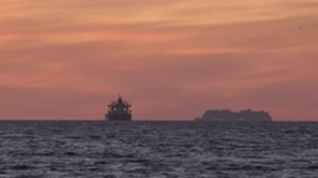 HUNTINGTON BEACH CALIFORNIA-2020: Two Ships Sail In A Red Sunset With Clouds In