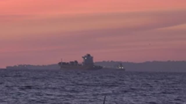 HUNTINGTON BEACH CALIFORNIA-2020: A Ship Floats On A Calm Sea With A Land Mass