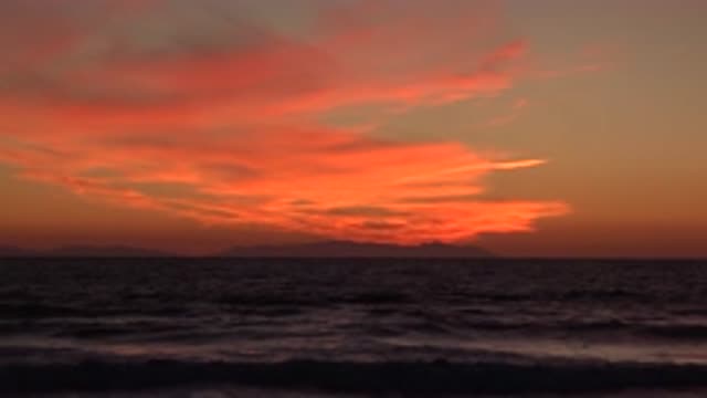 HUNTINGTON BEACH CALIFORNIA-2020: Billowing Waves On Seashore With A Fiery Sunset