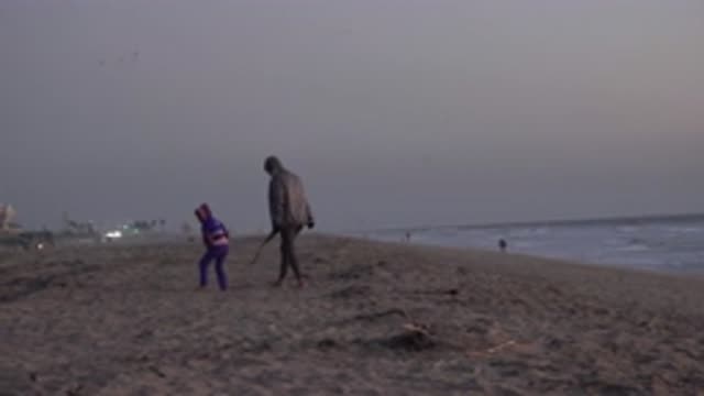 HUNTINGTON BEACH CALIFORNIA-2020: A Small Kid Is Picking Up Small Woods With His