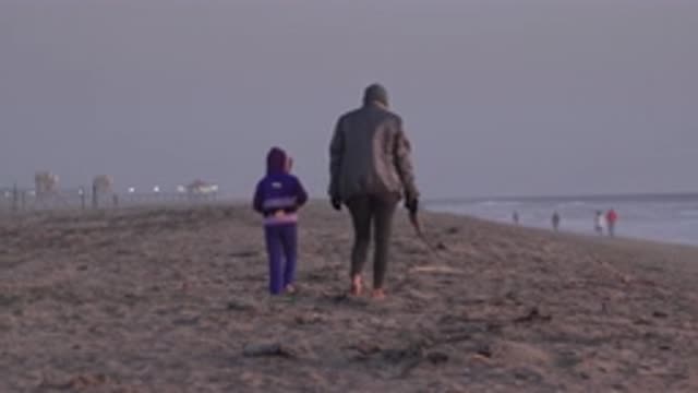 HUNTINGTON BEACH CALIFORNIA-2020: Mother And Son Taking An Evening Walk Down The Beach
