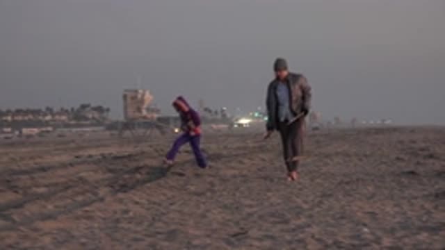 HUNTINGTON BEACH CALIFORNIA-2020: Woman And Young Girl Walks Barefoot With