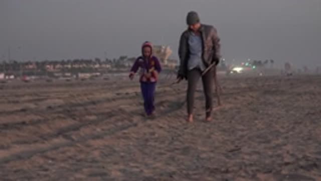 HUNTINGTON BEACH CALIFORNIA-2020: A Mother And Daughter Walking Barefoot Down