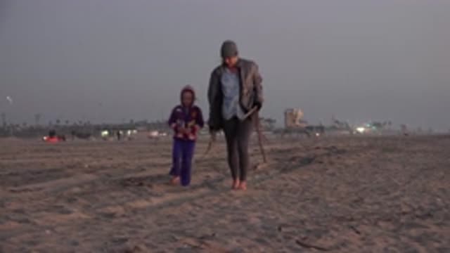 HUNTINGTON BEACH CALIFORNIA-2020: Footprints In The Sand As Child And Parent Walk At Sunset