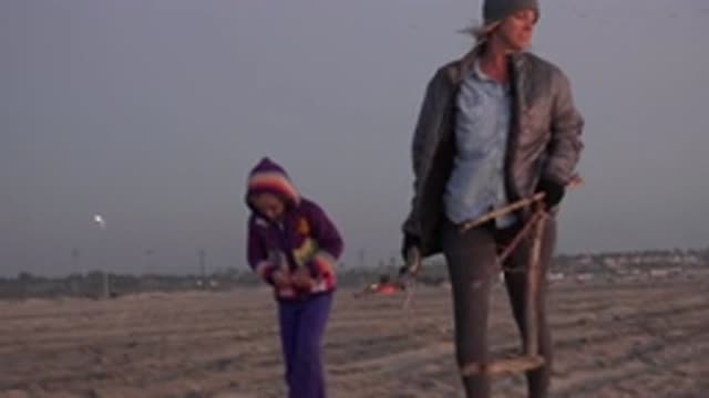 HUNTINGTON BEACH CALIFORNIA-2020: A Little Girl And Her Mother Are Picking Up Driftwood